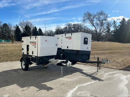 Two Generac whole-home generators sit on respective trailers for easy transport.