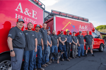 The A&E Plumbing, Heating and Air HVAC crew standing in front of a red A&E company van.