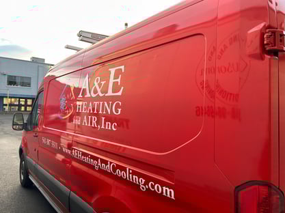 A shot of an A&amp;E van with the A&amp;E Plumbing, Heating and Air Gresham location in the background.